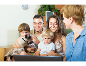 Family gathered around computer with cat
